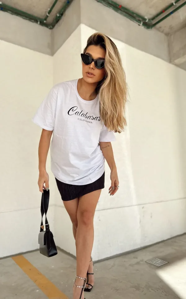 T-shirt feminina 100% Algodão Estampa Calabasas: estampa branca na peça de cor preta, rosa, laranja, esmeralda, cinza, mescla e vermelha, estampa preta básica na peça de cor areia, branca, combina com jeans, alfaiataria, perfeito para o dia a dia. Monte looks despojados e super confortáveis.