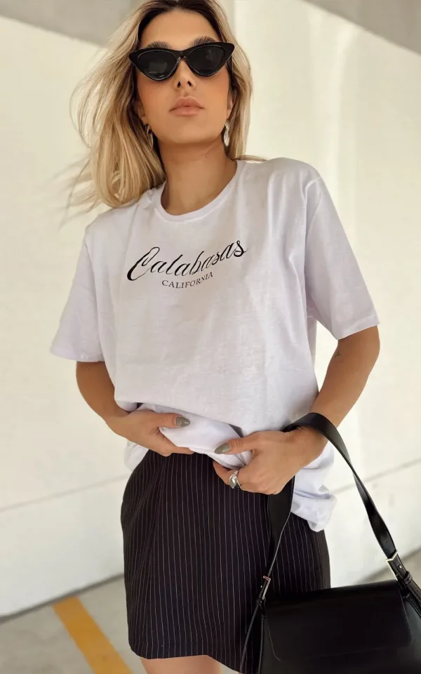 T-shirt feminina 100% Algodão Estampa Calabasas: estampa branca na peça de cor preta, rosa, laranja, esmeralda, cinza, mescla e vermelha, estampa preta básica na peça de cor areia, branca, combina com jeans, alfaiataria, perfeito para o dia a dia. Monte looks despojados e super confortáveis.